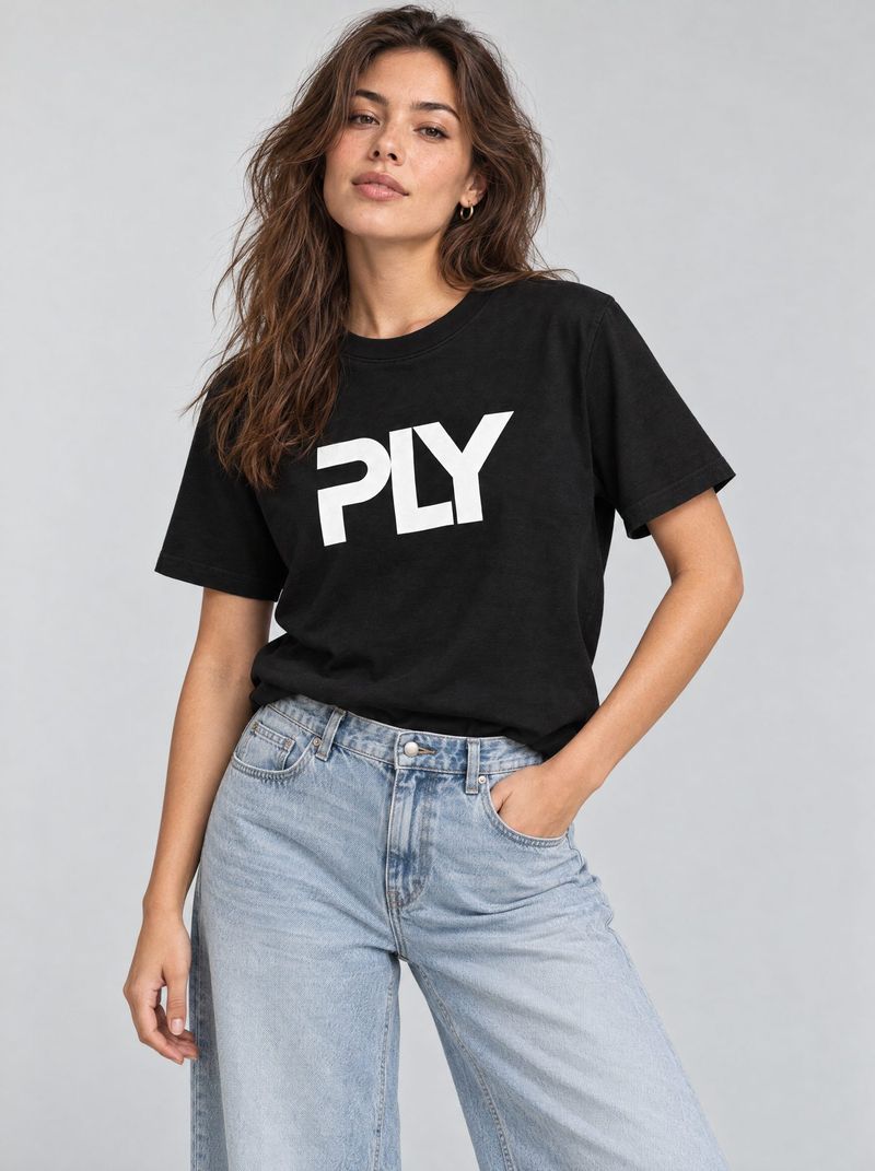 Model im Studio trägt das schwarze PLY-T-Shirt zu heller Jeans